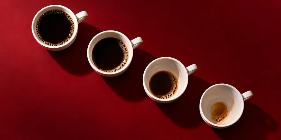 Fyra kaffekoppar i rad, från full till nästan tom